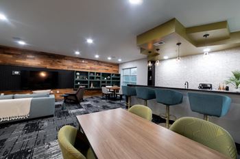 a living room and dining room with a table and chairs at 310 at Nulu Apartments-Student, Louisville Kentucky